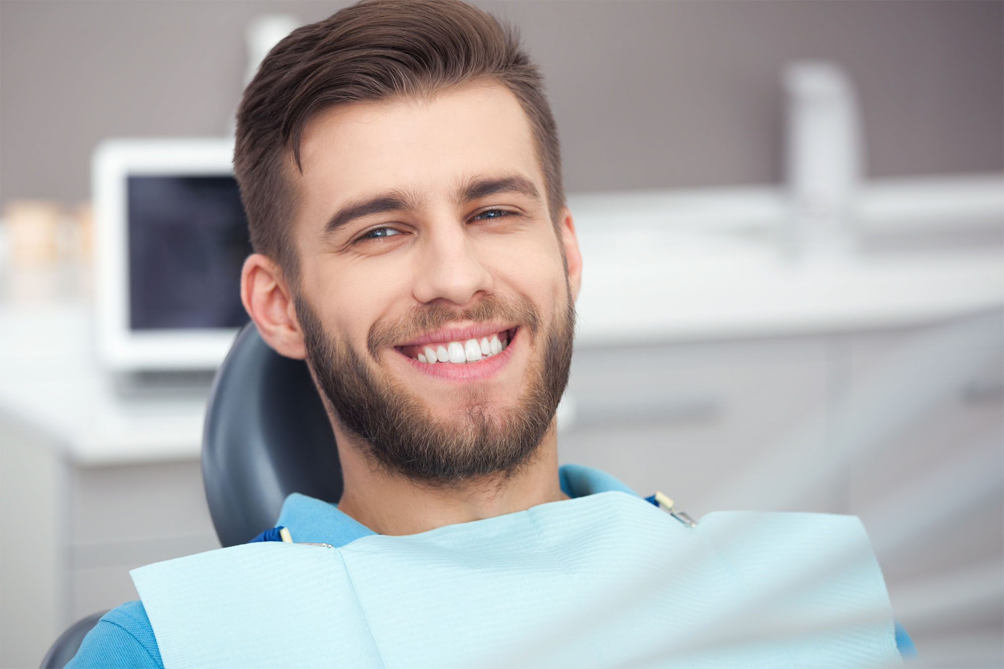 Young male patient smiling in the dental chair