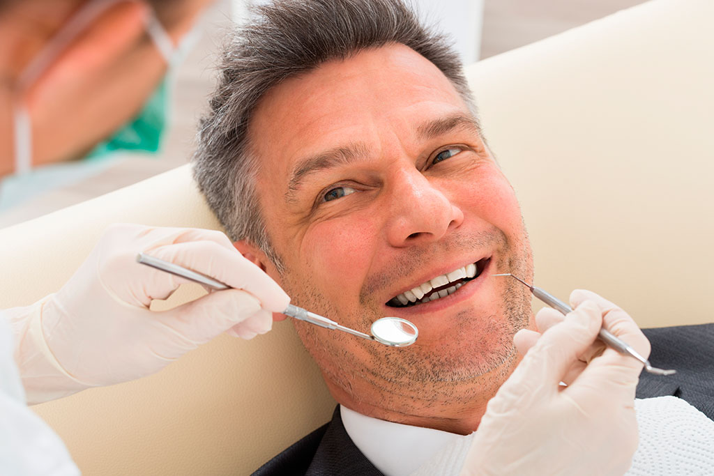 Middle-aged man getting his teeth examined
